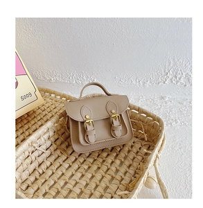 Gros plan sur le mini sac vintage beige avec boucles dans un panier en osier