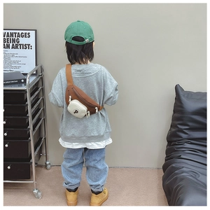 Rear view of a child wearing a stylish brown canvas chest bag with 'P' embroidery