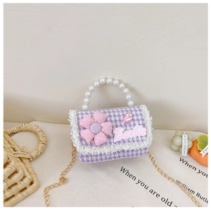Detail of tweed princess bag with pearl handle, pink flower, and gold chain strap