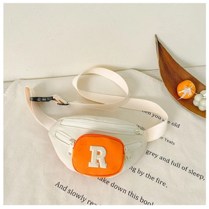 Detail of kids crossbody bag showing orange zip pocket and towel embroidered letter R