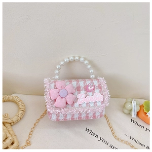 Detail of pink tweed flower girl bag with pearl handle and metal chain strap