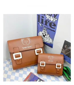 Detail view of caramel PU leather backpacks featuring cartoon bear prints and white buckles