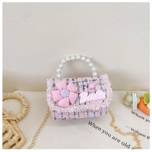 Close-up of pink tweed girl's bag with pearl handle and Barbie logo detail