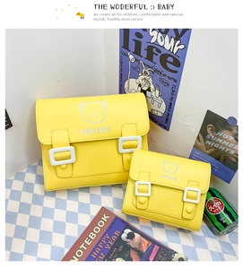 Detailed view of yellow PU messenger bags with cute bear prints and white square buckles