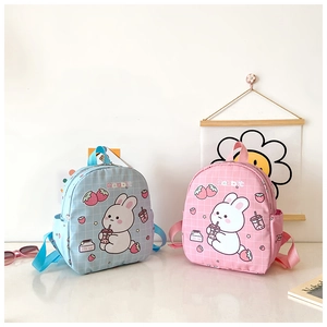 Dettaglio di zaini per bambini in tela rosa e blu con graziose stampe di coniglietti