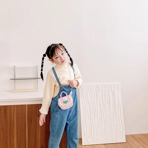 Pink tweed girls flower shoulder bag with pearl handle and lace detail worn by a child