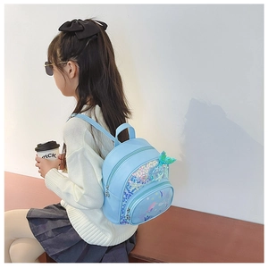 Détail d'une petite fille portant un sac à dos sirène bleu à paillettes avec queue de poisson