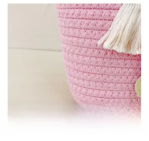 Gros plan du sac pour enfants en corde de coton tressé rose avec détails de pompons