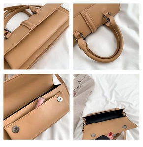 Detail view of khaki structured handbag showing handle, magnetic closure and inner lining