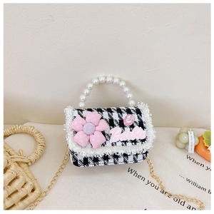 Detail of kids pearl handle handbag with pink floral decor and houndstooth pattern
