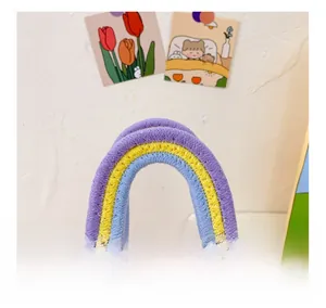 Gros plan sur la poignée tressée arc-en-ciel et la texture rose du sac en tricot