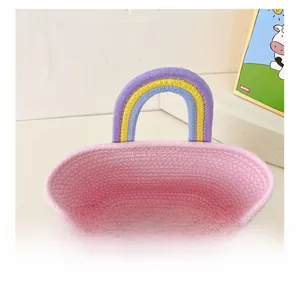 Détail intérieur du sac tressé montrant la doublure rose et l'anse arc-en-ciel colorée