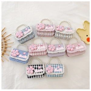 Detailed view of tweed mini bags with pearl handles, floral charms and Barbie logo
