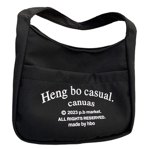 Minimalist black canvas shoulder bag for kids featuring bold white letter prints and wide strap