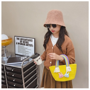 Détail du sac panier tressé jaune avec lapins en peluche et anse arc-en-ciel