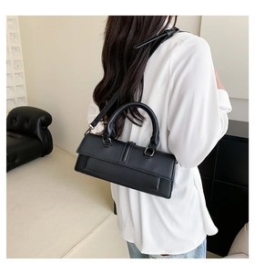 Minimalist black rectangular handbag with adjustable strap shown from a back perspective