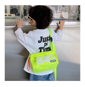 Detailaufnahme der neongrünen Nylon-Umhängetasche mit BAG-Schriftzug und orangefarbenem Zug