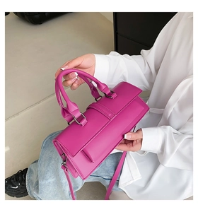Detail of rose purple structured handbag with top handles and detachable shoulder strap