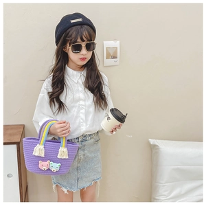 Détail d'un mini sac panier tissé violet avec oursons 3D et poignée à pompons colorés