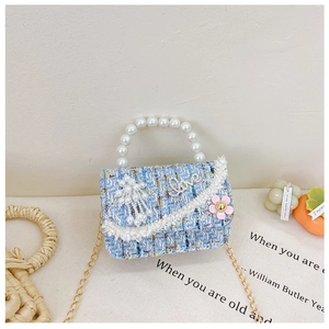 Detailaufnahme der blauen Tweed-Tasche mit Perlen griff und Strass-Love-Logo