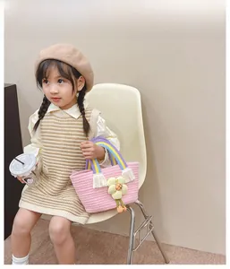 Vue détaillée du sac enfant tissé rose avec charme fleur et poignée arc-en-ciel
