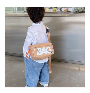 Details der khakifarbenen Kinder Umhängetasche mit BAG-Aufdruck und orangefarbenen Trägern