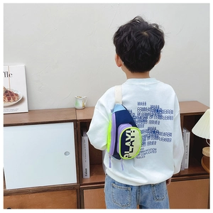 Detail of kids colorful crossbody bag with PLAY! text and adjustable strap on child