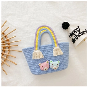 Détail du mini panier tissé bleu clair avec breloques d'ours et poignées arc-en-ciel