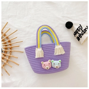 Détail du mini sac tressé violet avec poignée arc-en-ciel et écussons d'ours