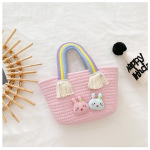 Détails de la texture du sac en tricot rose avec poignées arc-en-ciel et patchs lapin