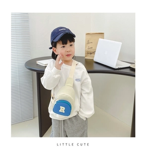 Detailed view of kids crossbody chest bag in beige and blue on a stylish young boy