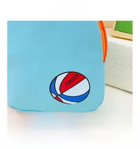 Détail d'un sac pour enfant en toile bleu ciel avec motif basketball et fermeture éclair orange