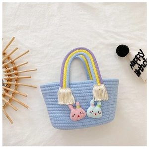 Détail du panier tressé bleu avec poignée arc-en-ciel et patchs animaux mignons