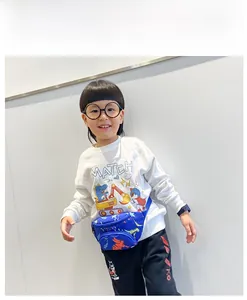 Dettaglio del marsupio blu in tela per bambini con simpatici motivi di dinosauri cartoni