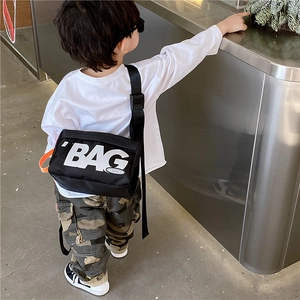 Schwarze Kinder Umhängetasche aus Nylon mit BAG Aufdruck und orangem Seiten-Detail