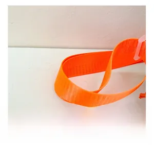 Détail de la bandoulière tissée orange vif avec boucle de réglage en plastique