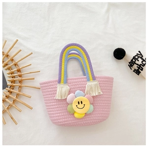Gros plan du sac tissé rose pour fille avec poignées arc-en-ciel et détail de tournesol souriant