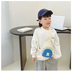 Close-up of a child wearing the stylish blue and cream nylon crossbody bag with letter R