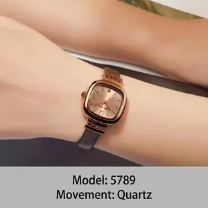 Elegant women's square quartz watch with rose gold dial and brown leather strap on wrist