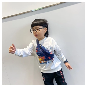 Bambino indossa un marsupio in tela blu navy con motivo a dinosauro rosso e scritta BAM