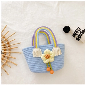 Détail du sac enfant bleu clair tissé main avec fleur jaune et poignée arc-en-ciel