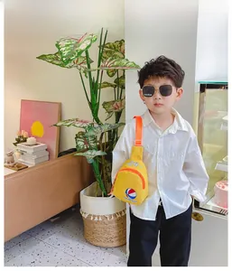Détail du sac de poitrine en toile jaune pour enfants avec motif basket et sangle orange
