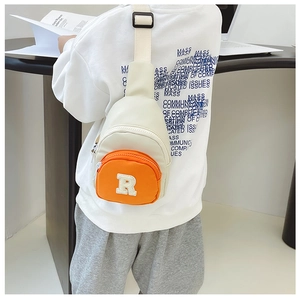 Rear view of a child wearing a cream and orange nylon crossbody bag with letter R embroidery