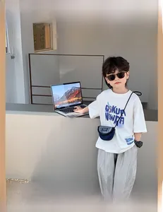Vue détaillée du sac bandoulière enfant en toile bleu et gris avec étiquette FASHION