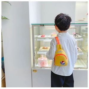 Détail du sac de poitrine jaune pour enfants avec motif basket et sangle orange vive