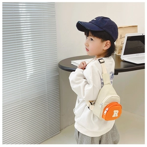 Close-up of kids nylon crossbody bag with contrast orange pocket and R embroidery