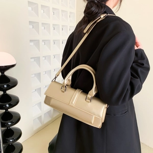 Minimalist rectangular gold shoulder bag with metallic finish shown on model in studio