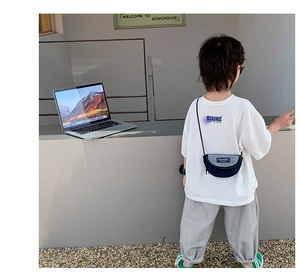 Gros plan sur le sac bandoulière demi-lune en toile bleu marine pour la mode enfantine