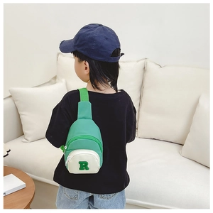 Detail view of the green kids nylon chest bag with letter R embroidery on a child
