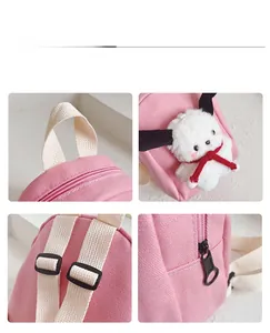Detailed view of pink canvas backpack featuring adjustable straps and plush dog ornament